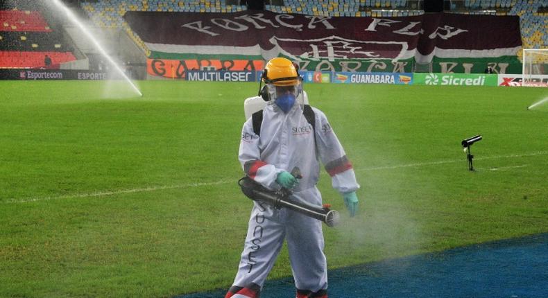 A worker disinfects the pitch at half time during the Rio de Janeiro state championship football final match between Flamengo and Fluminense at Maracana stadium, Rio de Janeiro, Brazil on July 15, 2020