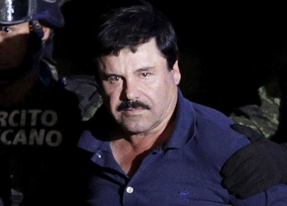 Recaptured drug lord Joaquin "El Chapo" Guzman is escorted by soldiers at the hangar belonging to the Attorney General in Mexico City, January 2016.