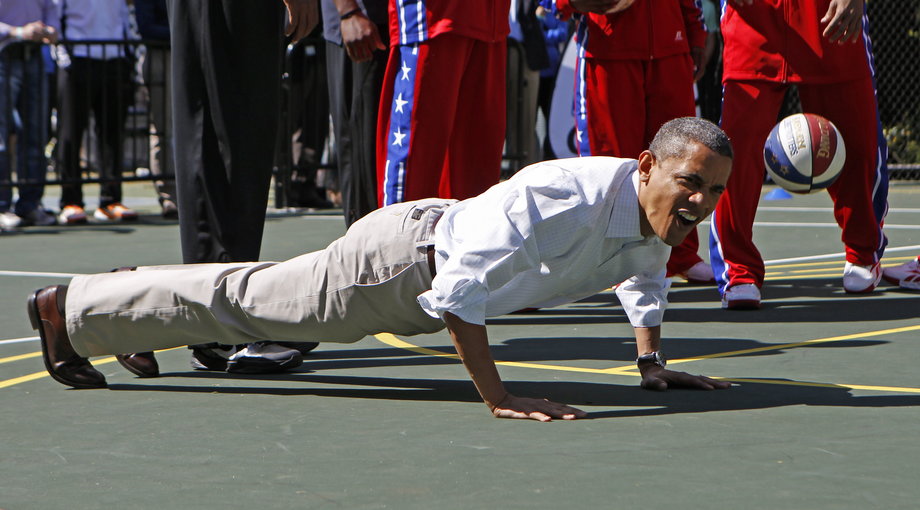 President Barack Obama does push-ups while playing basketball during the 2012 White House Easter Egg Roll on the South Lawn in Washington, April 9, 2012.