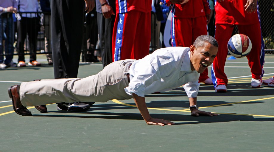 President Barack Obama does push-ups while playing basketball during the 2012 White House Easter Egg Roll on the South Lawn in Washington, April 9, 2012.