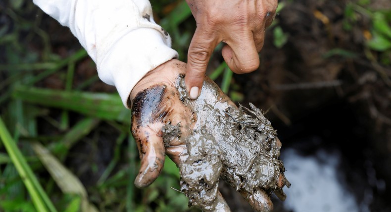 A man shows oil contamination inside Block 192, a dormant Amazon oil field in Peru.Reuters