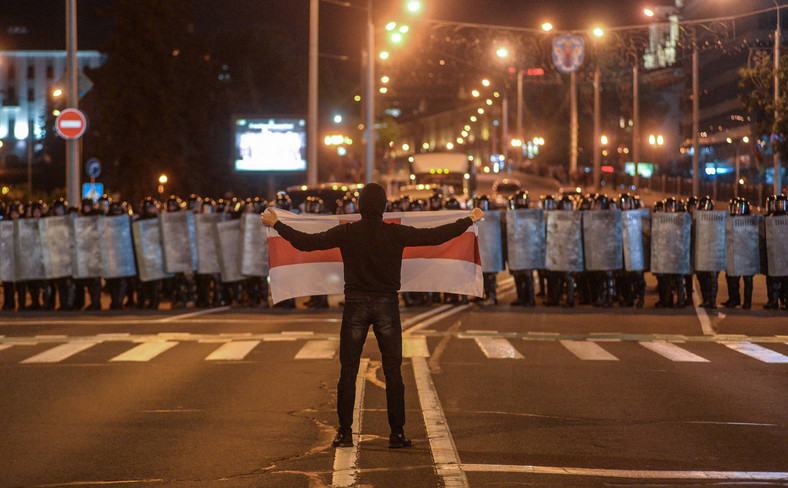 Demonstrant w Mińsku trzyma biało-czerwono-białą flagę w proteście po sfałszowaniu wyborów prezydenckich na Białorusi, 09 sierpnia 2020 r.