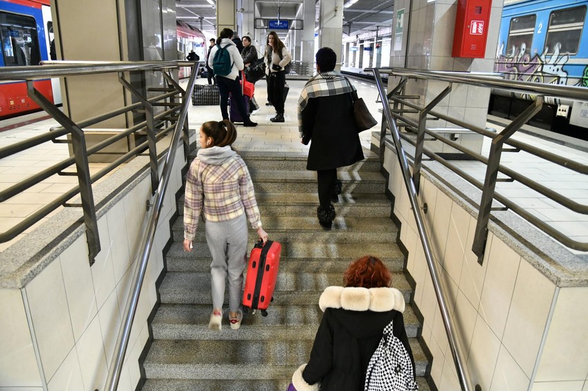 Putnici nose prtljag uz stepenište