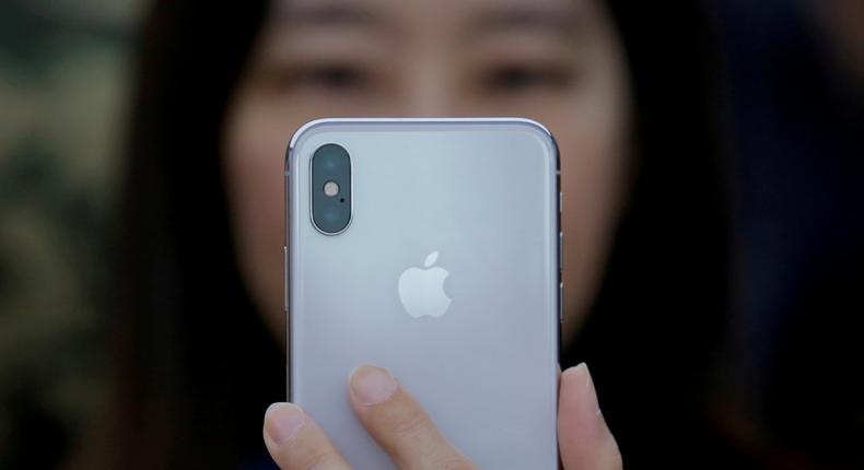 FILE PHOTO: A attendee uses a new iPhone X during a presentation for the media in Beijing, China October 31, 2017. REUTERS/Thomas Peter/File Photo