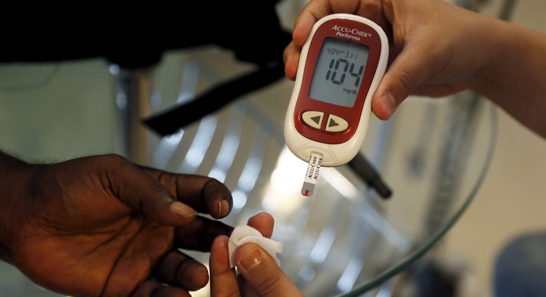 A paramedic checking the blood sugar levels of a diabetes patient.