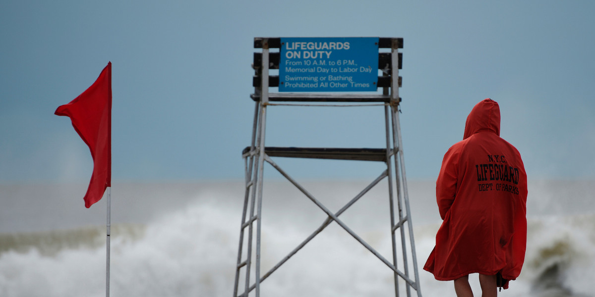 A lifeguard surveys the water where surfers took advantage of the waves at Rockaway Beach in Queens, New York.