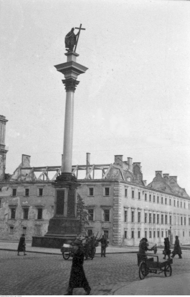 Warszawa. Przechodnie na placu Zamkowym i zniszczony Zamek Królewski (1940 r.)