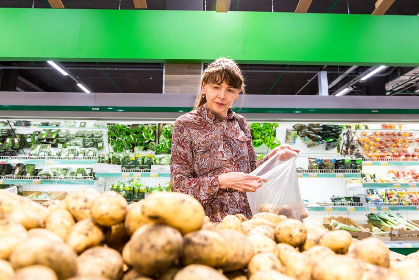 Young woman choosing fresh potatoes