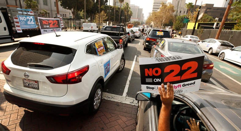 Rideshare driver Jorge Vargas raises his No on 22 sign in support as app based gig workers held a driving demonstration with 60-70 vehicles blocking Spring Street in front of Los Angeles City Hall urging voters to vote no on Proposition 22, a November ballot measure that would classify app-based drivers as independent contractors and not employees or agents, providing them with an exemption from Californias AB 5. The action is part of a call for stronger workers rights organized by the Mobile Workers Alliance with 19,000 drivers in Southern California and over 40,000 in all of California.
