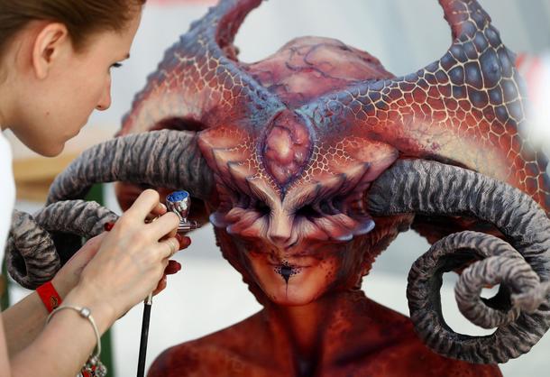 An artist airbrushes a model during the World Bodypainting Festival 2017 in Klagenfurt