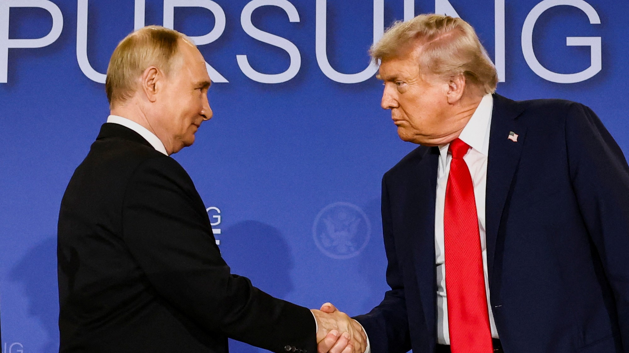 Americký prezident Donald Trump a ruský prezident Vladimir Putin si podávajú ruky počas tlačovej konferencie po samite na Aljaške.