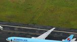 An aerial picture shows passengers standing near a Korean Air Lines plane after smoke rose from one of its engines at Haneda airport in Tokyo