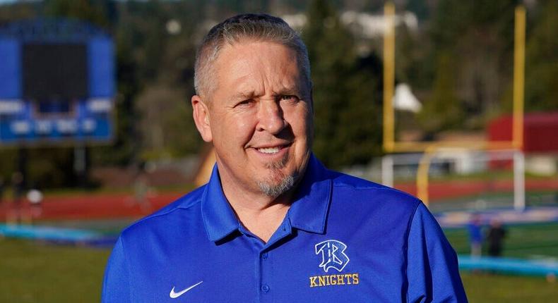 Joe Kennedy, a former assistant football coach at Bremerton High School in Bremerton, Wash., poses for a photo March 9, 2022, at the school's football field.