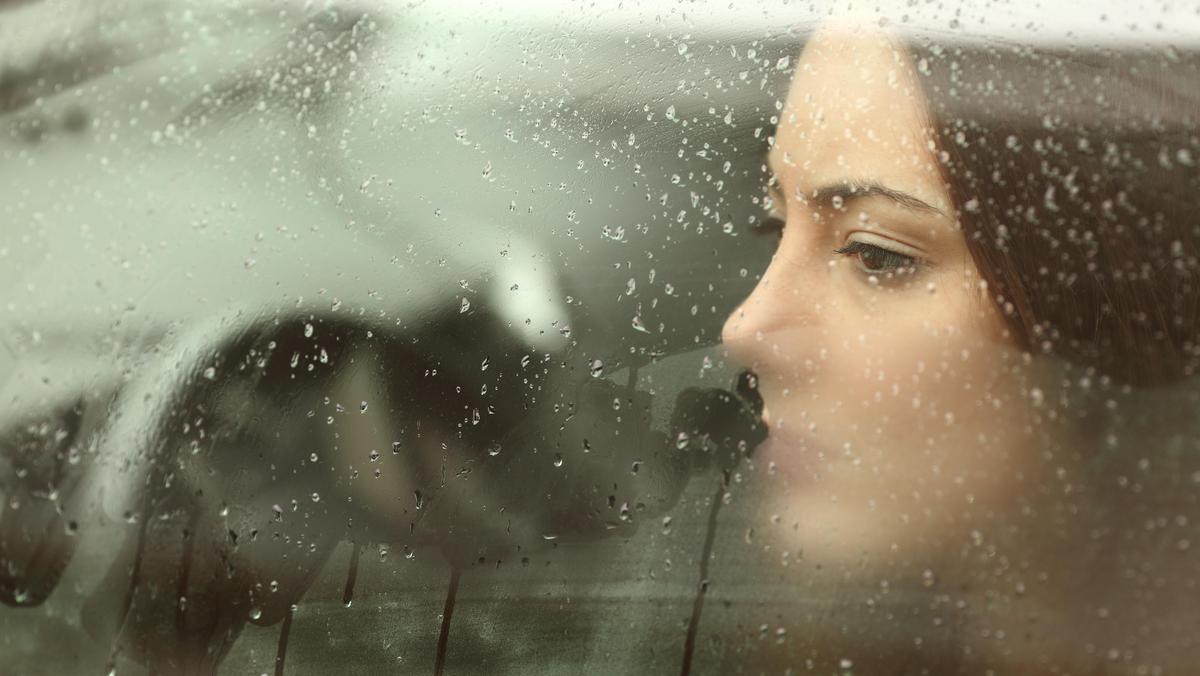 Sad woman looking through a car window