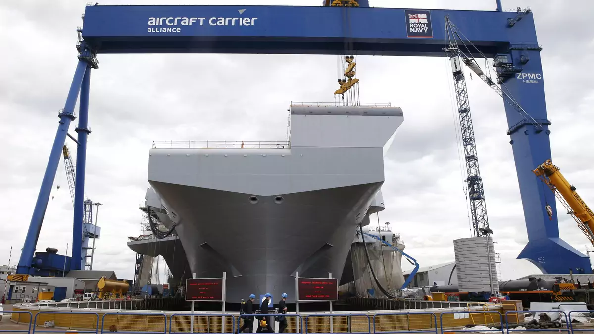 File photograph of workers in front of HMS Queen Elizabeth, the first of two aircraft carriers being built by British defence firm BAE Systems in Scotland