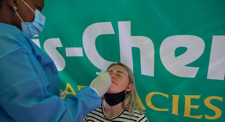 A healthcare worker conducts a COVID-19 test on a traveller at OR Tambo International Airport in Johannesburg on November 28, 2021,