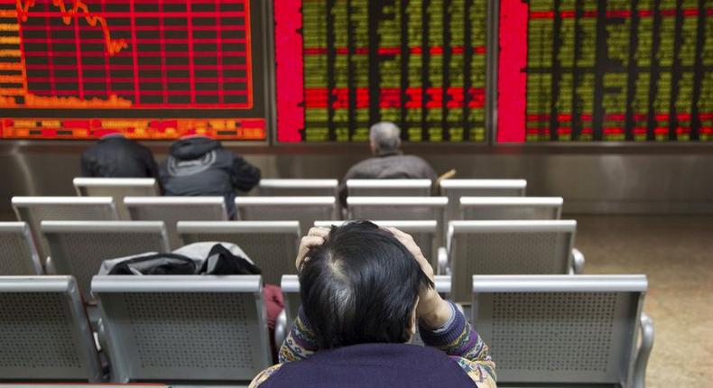 An investor sits in front of an electronic board showing stock information at a brokerage house in Beijing, China, November 30, 2015. REUTERS/Li Sanxian