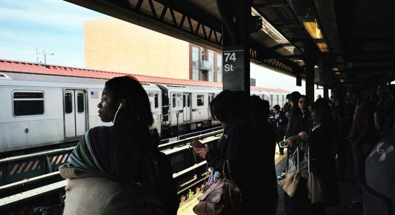 Morning commuters wait for their trains at a station in New York on May 11, 2016