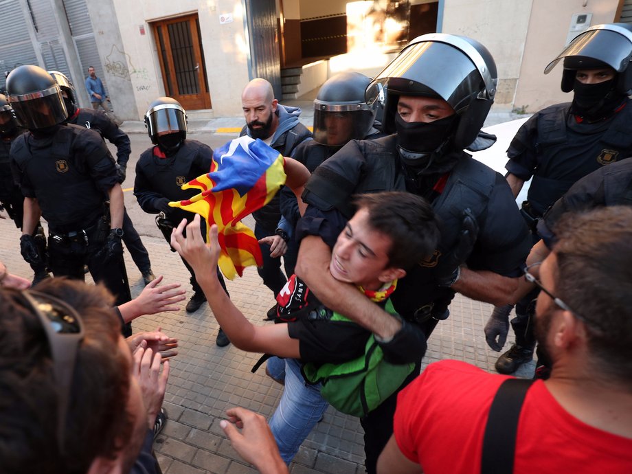 Spanish police forcibly remove a protester outside a Unipost office following a raid on Tuesday.