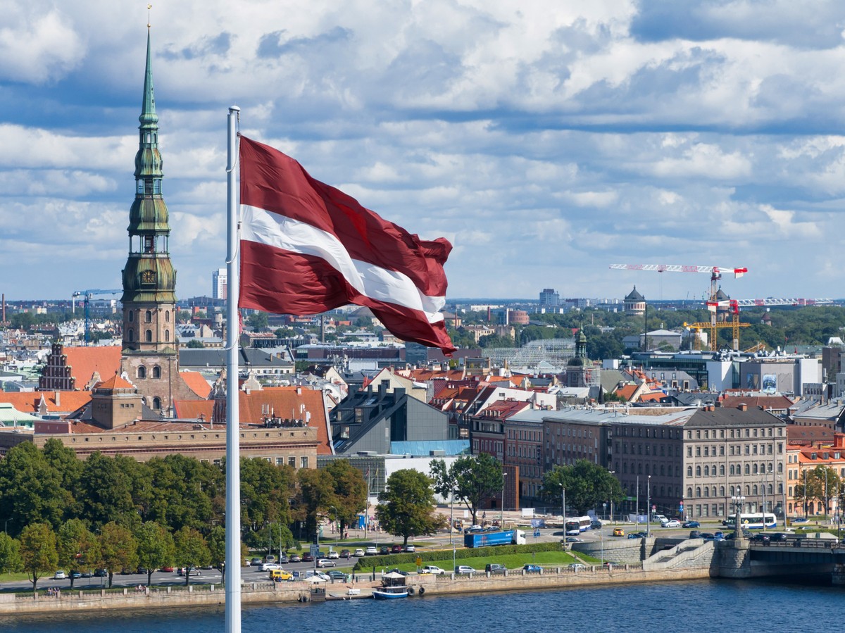 Ryga, Łotwa – flaga narodowa Łotwy na tle miasta