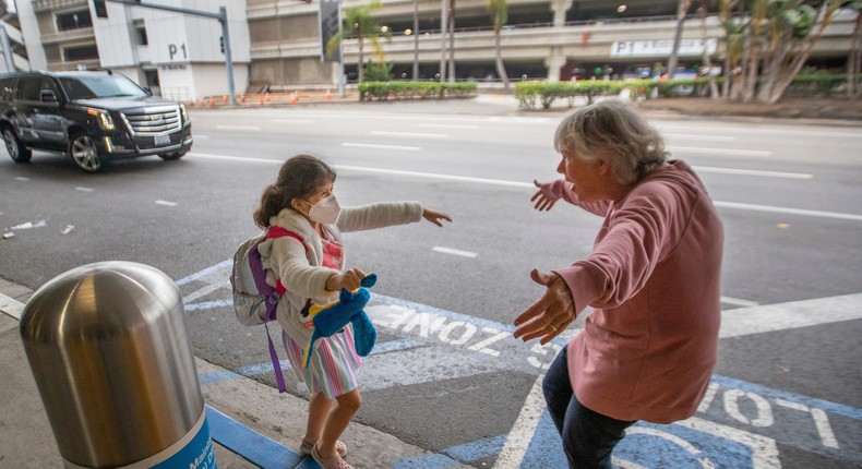 Seven-year-old Jacquie Carney runs to hug her grandma, Donna Vidrine, upon arrival in Los Angeles, California on November 23, 2020.
