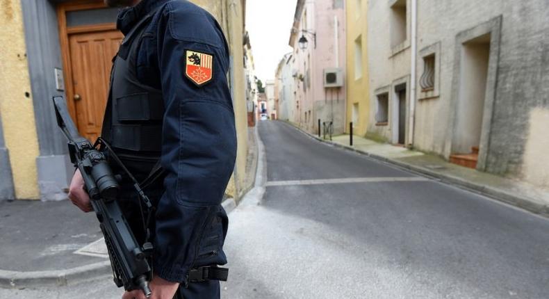 An armed gendarme stands guard in a street in Marseillan, southern France, on February 10, 2017, where the suspects were arrested by French anti-terrorist police