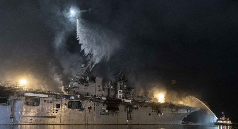 A helicopter from Helicopter Sea Combat Squadron (HSC) 3 combats a fire aboard the amphibious assault ship USS Bonhomme Richard (LHD 6) at Naval Base San Diego, July 14