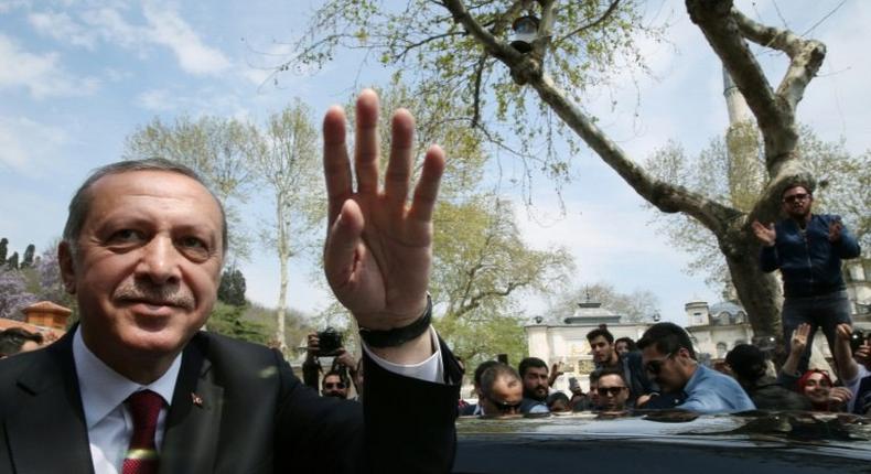Turkish President Recep Tayyip Erdogan (L) greeting supporters during his visit to the Eyup Sultan Mosque in Istanbul the day after his victory in a national referendum on April 17, 2017