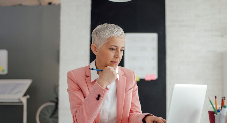 Woman working at an office desk and note-taking