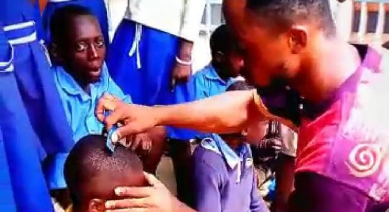 Dancing teacher Percy Sackey cuts his pupils hair