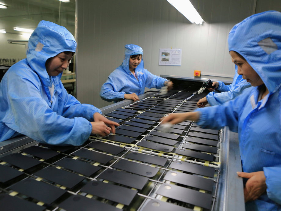 Workers process laptop accessories at a factory in China.