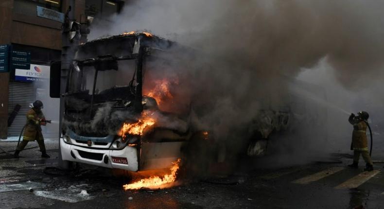 Civil servants protesting against austerity measures clash with riot police and set fire to a bus on Rio Branco, the main avenue in Rio de Janeiro, Brazil, while firefighters attempt to put out the blaze, on February 1, 2017