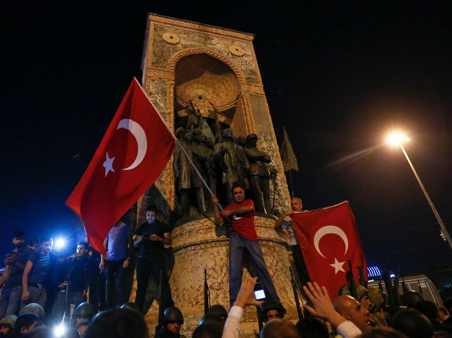 Turkish military stand guard near Taksim Square as people wave Turkish flags in Istanbul on July 16.