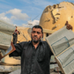 A man holds books of the Quran in front of a mosque destroyed by Israeli airstrikes.