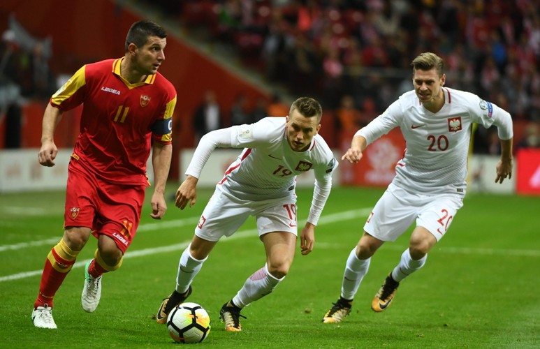 Polacy Piotr Zieliński (C) i Łukasz Piszczek (P) oraz Fatos Beciraj (L) z Czarnogóry