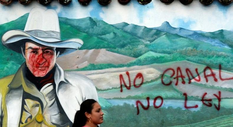 A woman is seen in front of a wall with a graffiti reading No canal, no law during a protest against the construction of an inter-oceanic canal in Juigalpa, Nicaragua on June 13, 2015