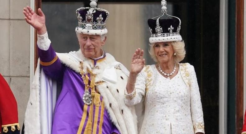 King Charles III and Queen Camilla in lavish robes and wearing their crowns return with a wave the cheers of the crowds and set the seal on their historic coronation day with a Buckingham Palace balcony appearance to acknowledge the nation..