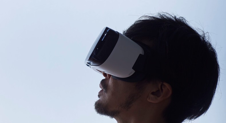 A stock image shows a man using a virtual reality headset.
