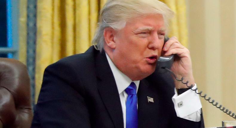 U.S. President Donald Trump speaks on the phone with Prime Minister of Australia Malcolm Turnbull in the Oval Office of the White House, Saturday, Jan. 28, 2017 in Washington.