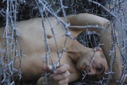 Pawlenski Pawleński Artist Pyotr Pavlensky lies on the ground, wrapped in barbed wire roll, during a protest action in St. Petersburg