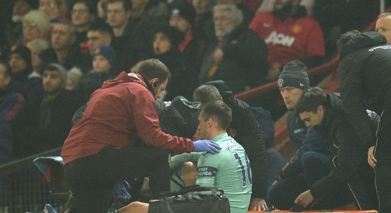 Arsenal defender Rob Holding receives medical attention at Old Trafford