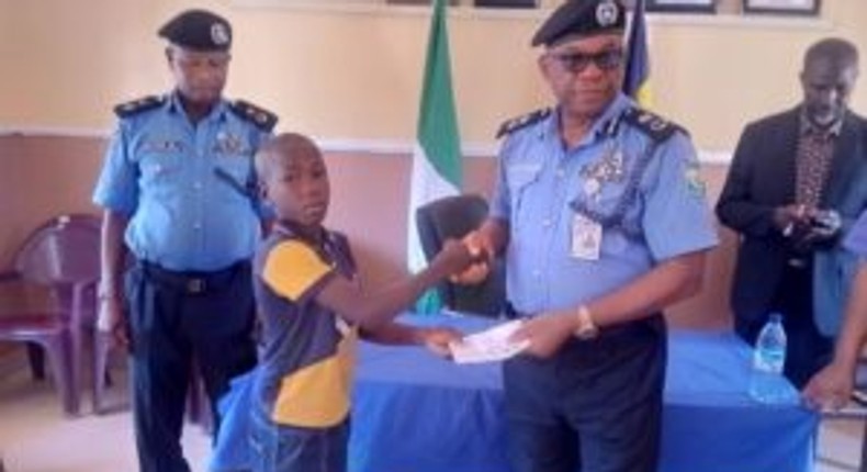 L-R: L-R: One of the deceased police officers’ children receiving a cheque from Kebbi Police Commissioner, CP Chris Aimionowane, in Birnin Kebbi on Thursday [NAN]
