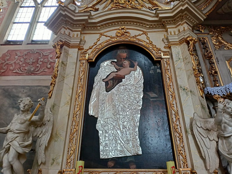 Piękna szata, w którą odziany jest św. Józef trzymający małego Jezuska.