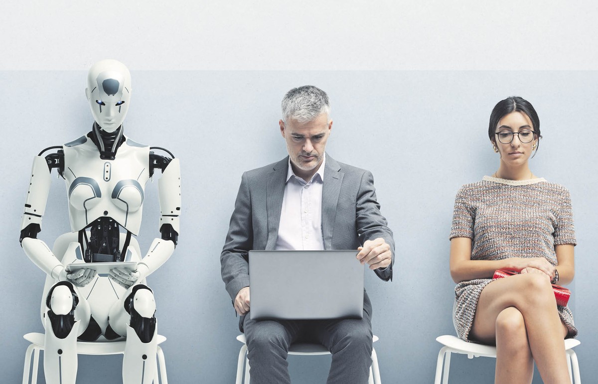 Pomieszczenie sugerujące poczekalnię przed rozmową o pracę. Na dwóch krzesłach siedzą ludzie, a na jednym z nich humanoidalny robot.