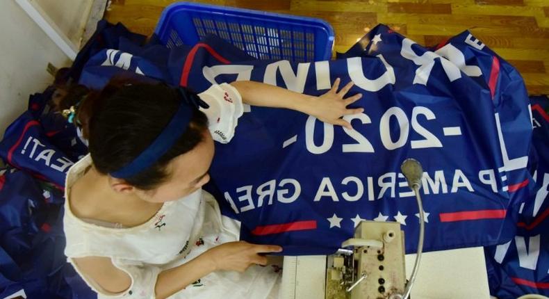 A worker at a factory in China sews a banner for US President Donald Trump's re-election campaign that reads Trump 2020: Keep America Great