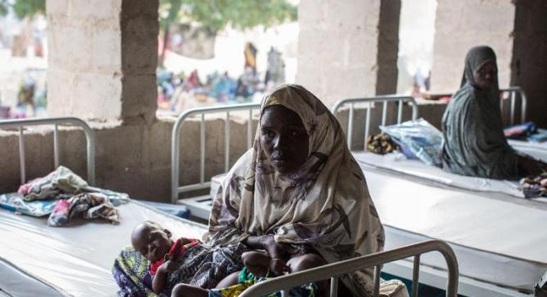 A woman rests with her twin babies in a maternity ward in Maiduguri, Borno State on March 25, 2015 