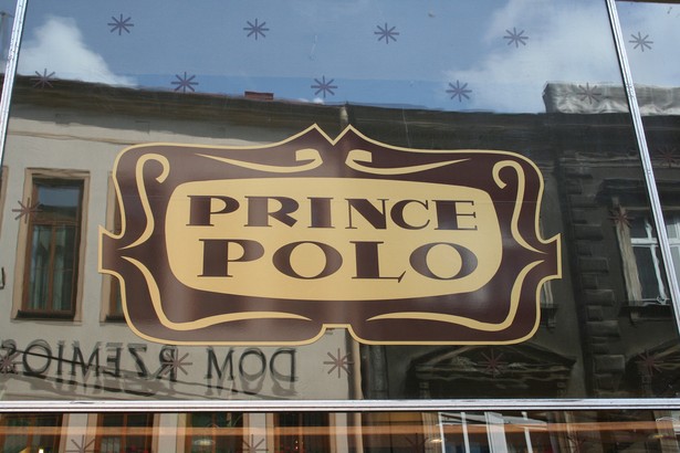 Wafelek Prince Polo. Produkt ten na rynek wprowadzono w 1955 roku, a miejscem jego narodzin były zakłady produkcyjne cieszyńskiej firmy Olza. Polski wafel bardzo szybko zyskał sobie popularność w krajach byłego Bloku Wschodniego, a także na Islandii, gdzie był znany pod nazwą Prins Polo. O pokoleniowym wręcz wpływie polskiego wafla na Islandczyków najlepiej świadczą słowa byłego prezydenta Islandii Ólafura Ragnara Grímssona, który podczas wizyty w Polsce w 1999 roku powiedział „Całe pokolenie Islandczyków wyrosło na dwóch rzeczach – amerykańskiej coca-coli i polskim Prince Polo”. Na zdj. logo Prince Polo. Źródło: cocoate.com. Licencja CC BY 2.0