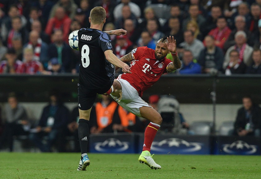 Bayern Munich's Arturo Vidal looks dejected after being sent off as Real Madrid's Sergio Ramos looks