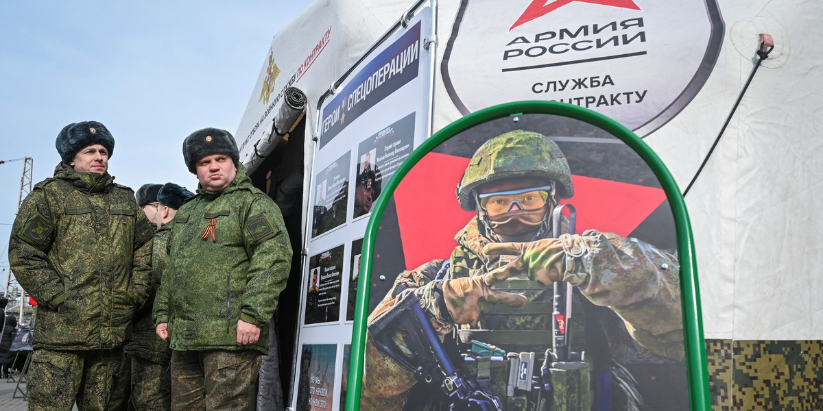 Żołnierze armii rosyjskiej przy mobilnym centrum rekrutacyjnym w Rostowie. Na tablicy plakat z poziomem zarobków w armii. Zdjęcie z 3 marca 2024 r.