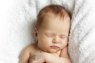 newborn baby sleeping on a white blanket